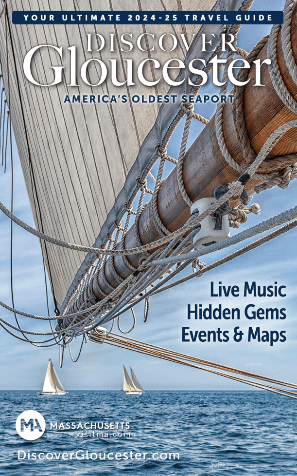 Close-up of sailboat rigging and ropes against a clear blue sky and calm sea, with small sailboats in the distance. Discover Gloucester’s guide is your travel companion to live music, hidden gems, local events, maps, and more.