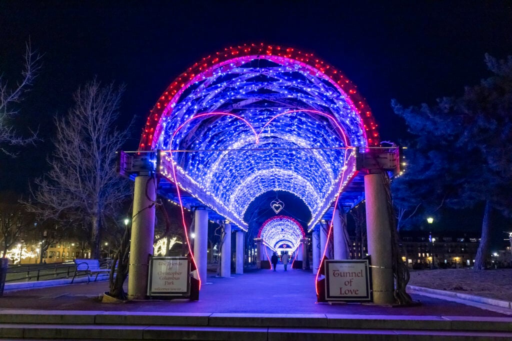 Lights illuminate an archway at night in Boston's Columbus Park.