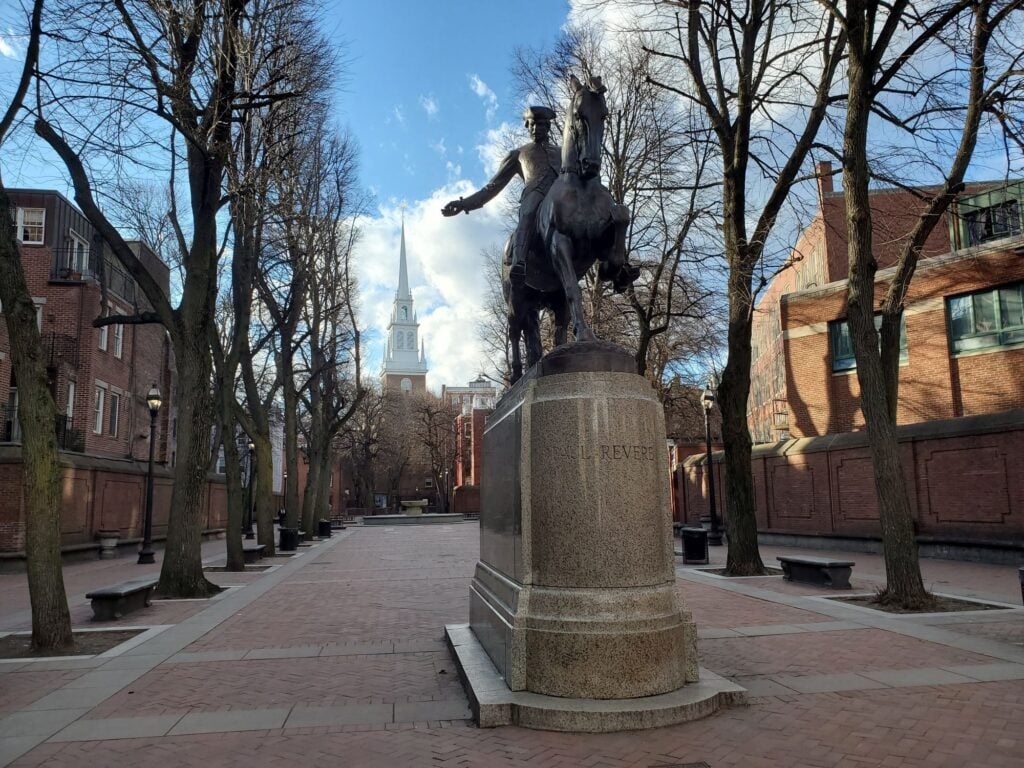 A statue of Paul Revere on horseback outside of the Old North Church.
