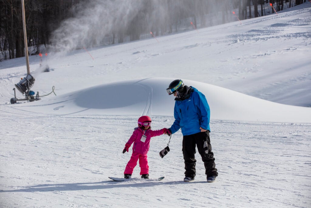 A father and daughter ski together at Catamount Mountain Resort.