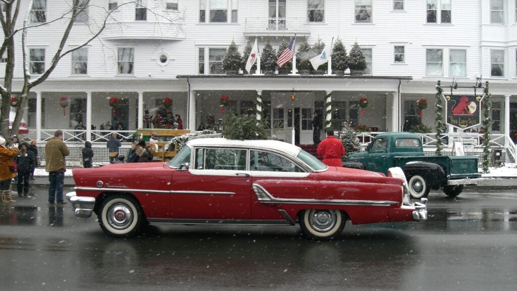 A classic red car drives in front of the Red Lion Inn in the Berkshires.