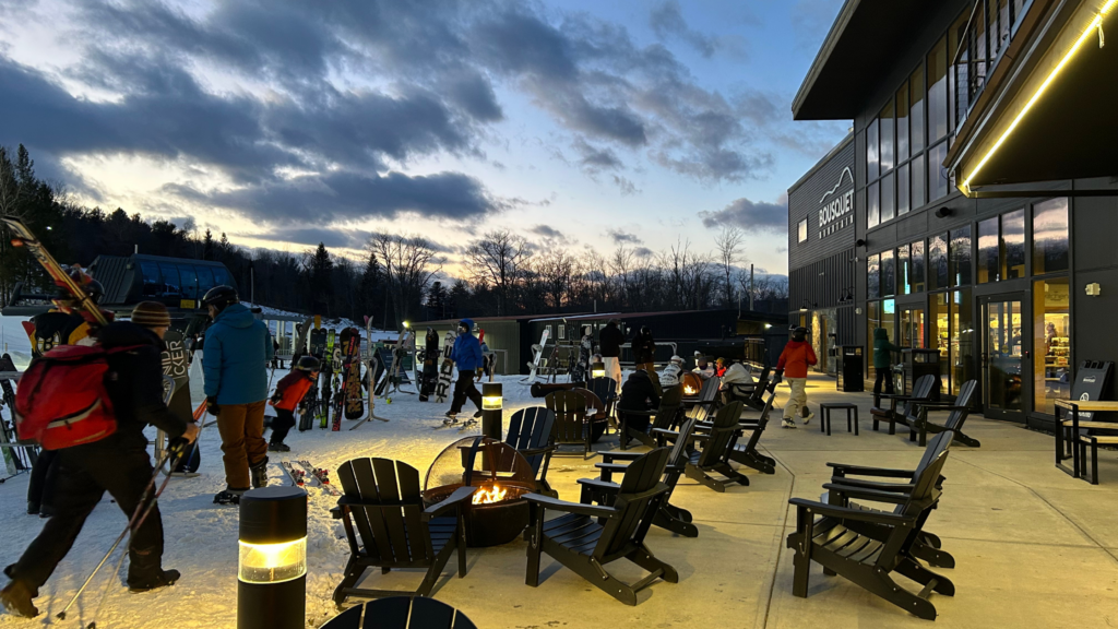 Lounge chairs set up outdoors overlooking a gorgeous night ski at a ski area.