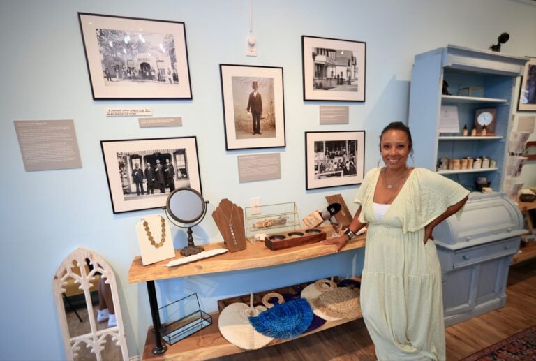 A shop owner stands in front of the artwork and jewelry they sell in Jubillee on Martha's Vineyard, Massachusetts.