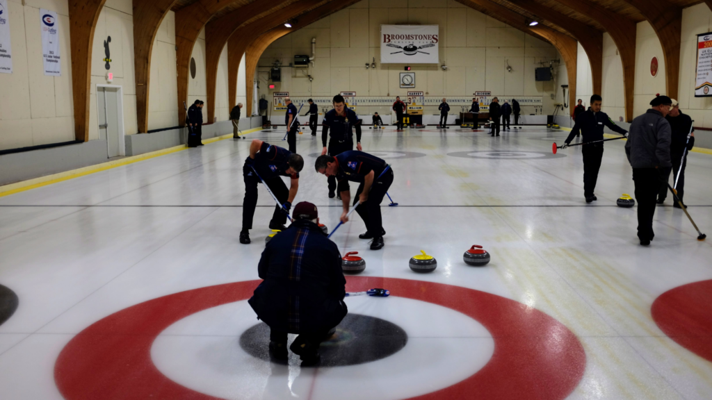 People try curling by brushing a large stone across a sheet of white ice.