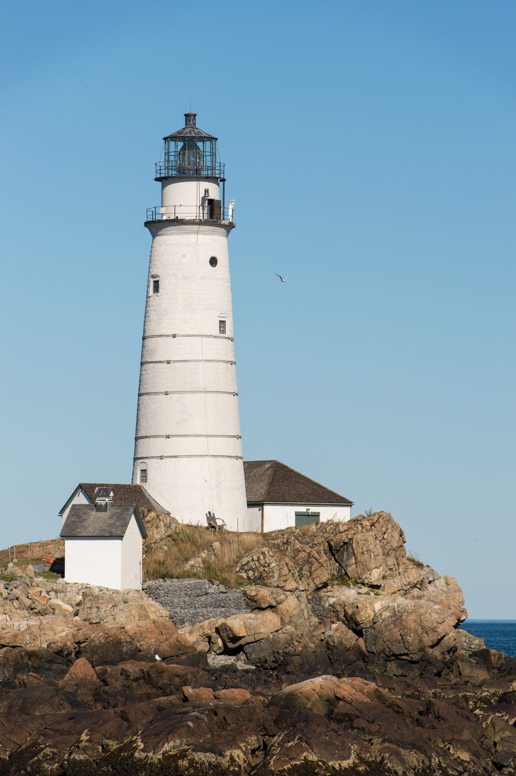 Boston Light, a white lighthouse on a rocky island.