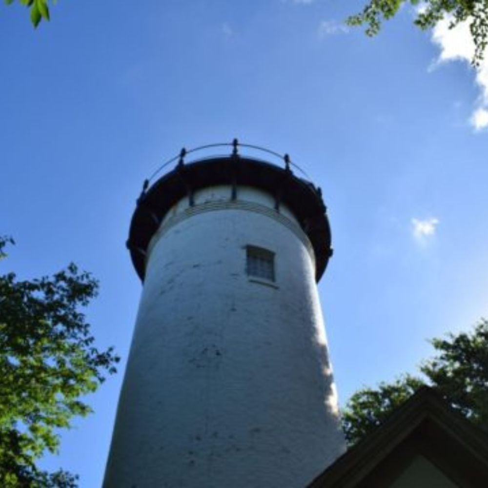 Long Island Light in Boston Harbor against a clear blue sky.