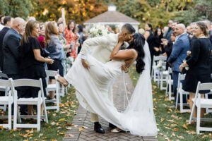 A groom and bride embrace in the aisle of their wedding.