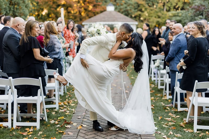 A groom and bride embrace in the aisle of their wedding.
