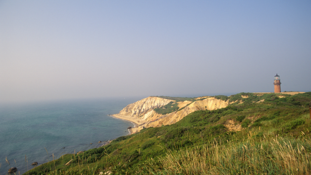 Earthy Aquinnah Cliffs and Gay Head Light against a blue sky - Credit Kindra Clineff