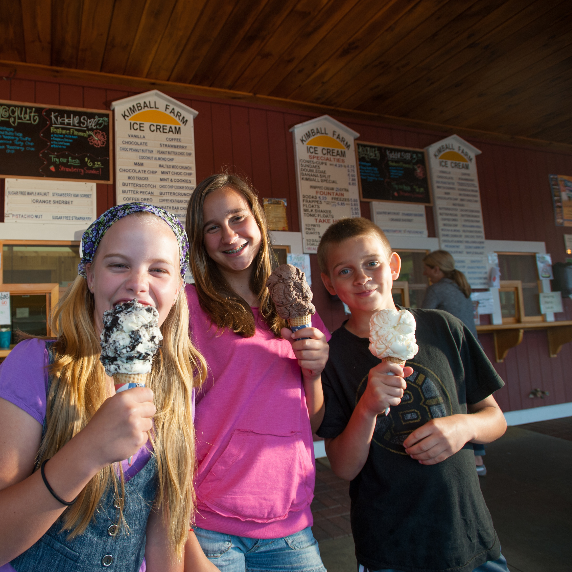 Three children enjoy ice cream cones.